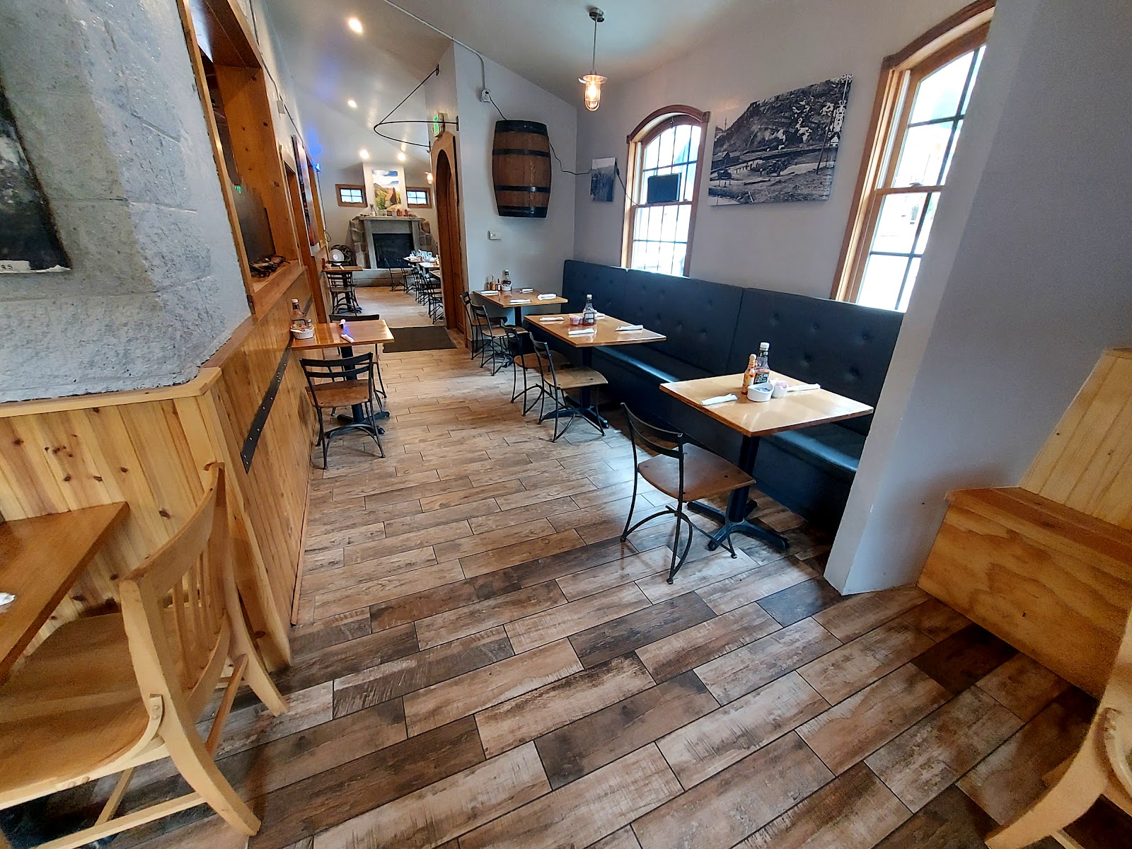 Dining room with wooden tables, chairs, and booth seating